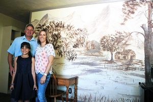 Jon Johnson Photo/Gila Valley Central: The Lazy Traveler owners and operators, from left, Jeff Taisto, Jaidyn Martinez and Frances Martinez stand in front of a mural of Mount Graham reportedly painted by a prison escapee while on the lam. The mural is in one of 14 rooms available for rent. 
