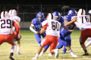 Contributed Photo/Courtesy L. Scott Bennett: Quarterback Manuel Aparicio attempts to squeeze through two Florence defenders. 