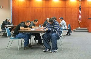 Photo By Kimberly Tremain: Applicants for construction jobs at the new Graham County Adult Detention Facility fill out paperwork during a hiring fair, Monday. 
