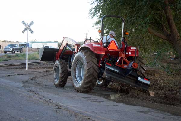 Jon Johnson Photo/Gila Valley Central: Bart Judd digs a trench with his tractor to alleviate his flooded corral. 