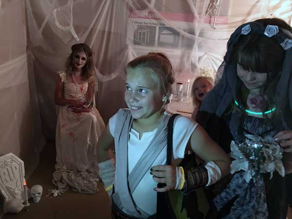 Jon Johnson Photo/Gila Valley Central: From left, a Home Depot employee watches as attendees Ambrosia Johnson and Lydia McElroy experience the spooky shed.