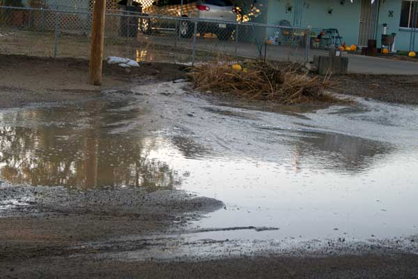 Jon Johnson Photo/Gila Valley Central: Water and debris pour out of a yard in Pima.