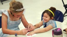 Eric Burk Photo/ Gila Valley Central: Cinderella paints Isabella Gonzales' fingernails purple at a Princess and Superhero Breakfast hosted by Safford High School's Taste of Sound Choir.